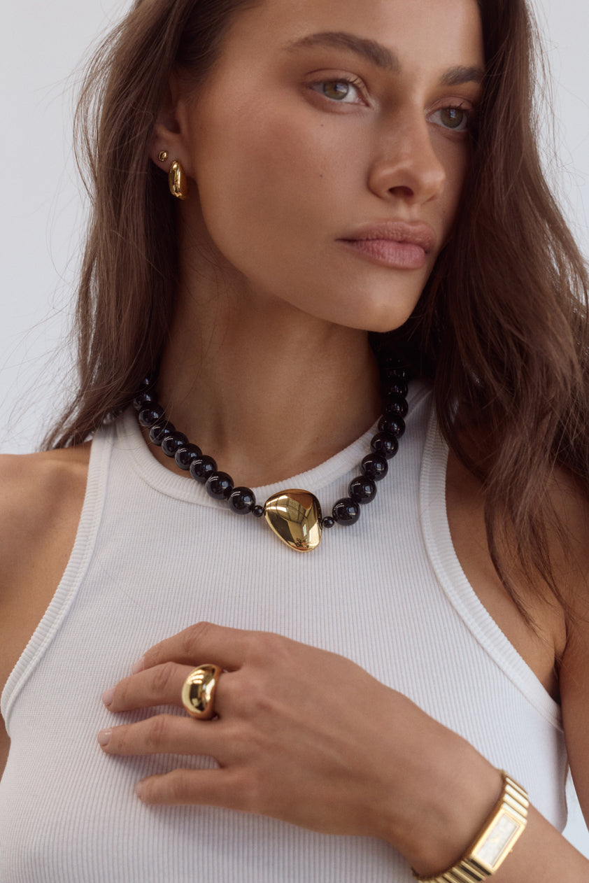 Cendré Enna gold teardrop earrings styled on a model