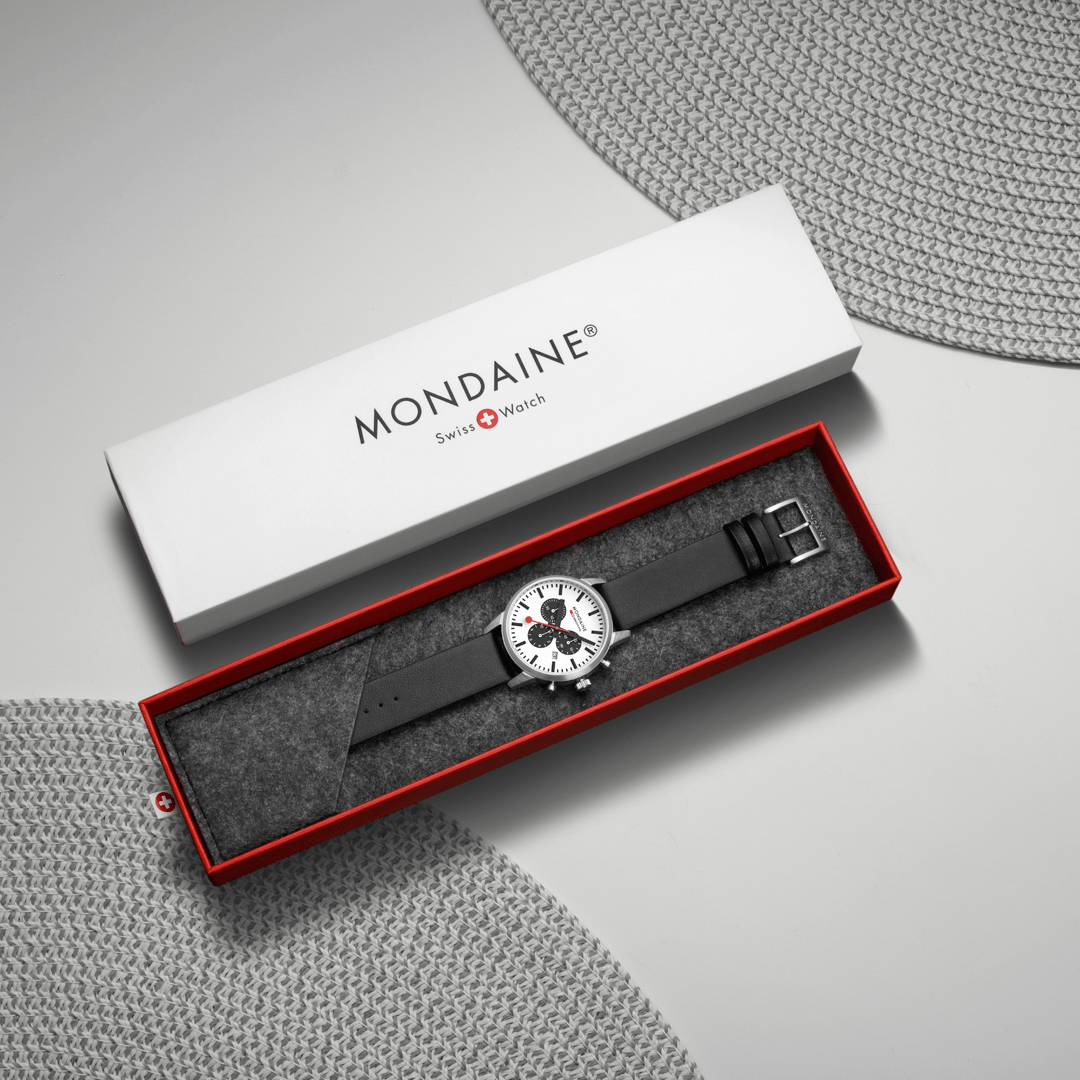 Wristwatch in an open Mondaine branded box with a red interior.