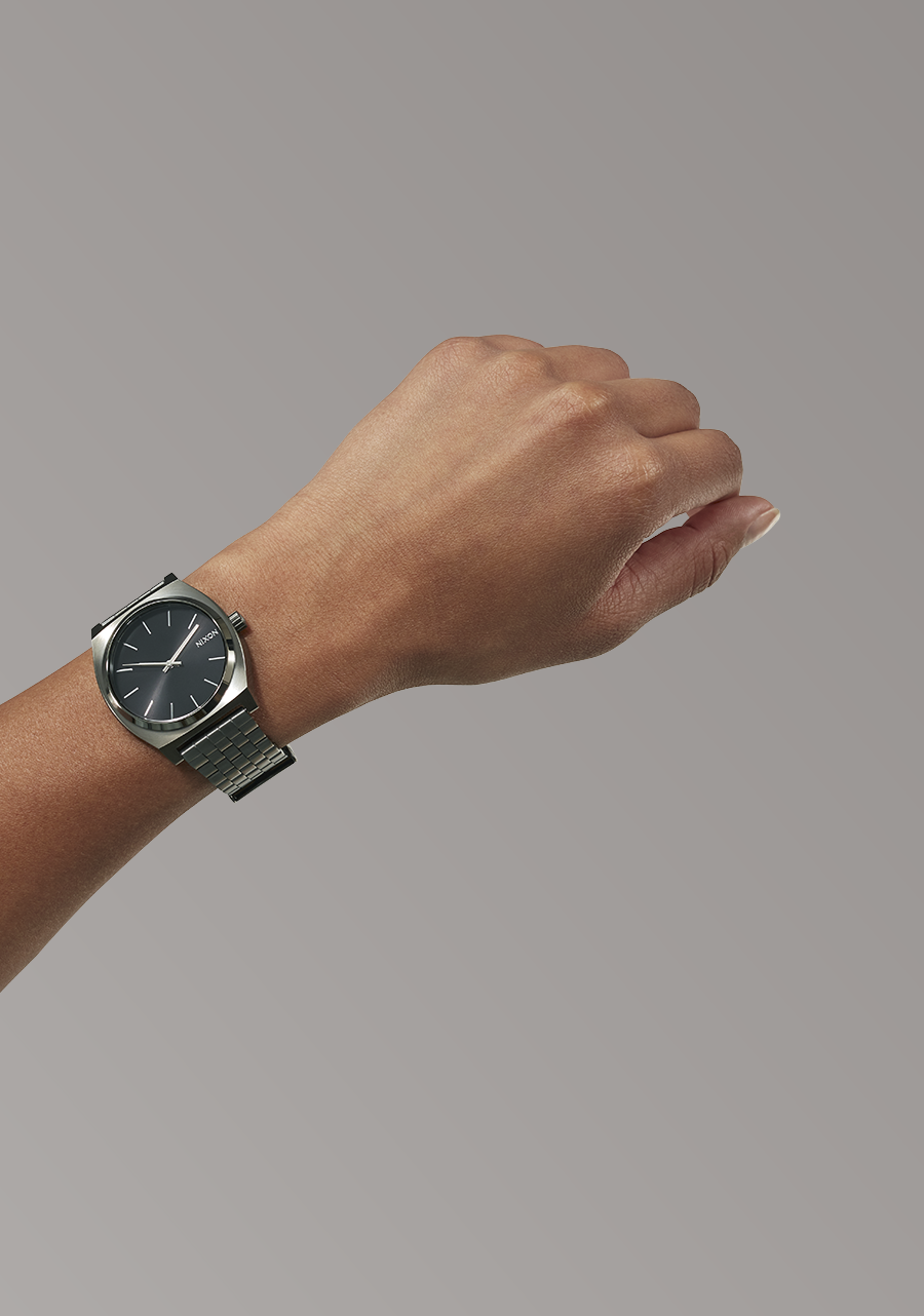 Wristwatch with a dark face and metal band worn on a person’s wrist.