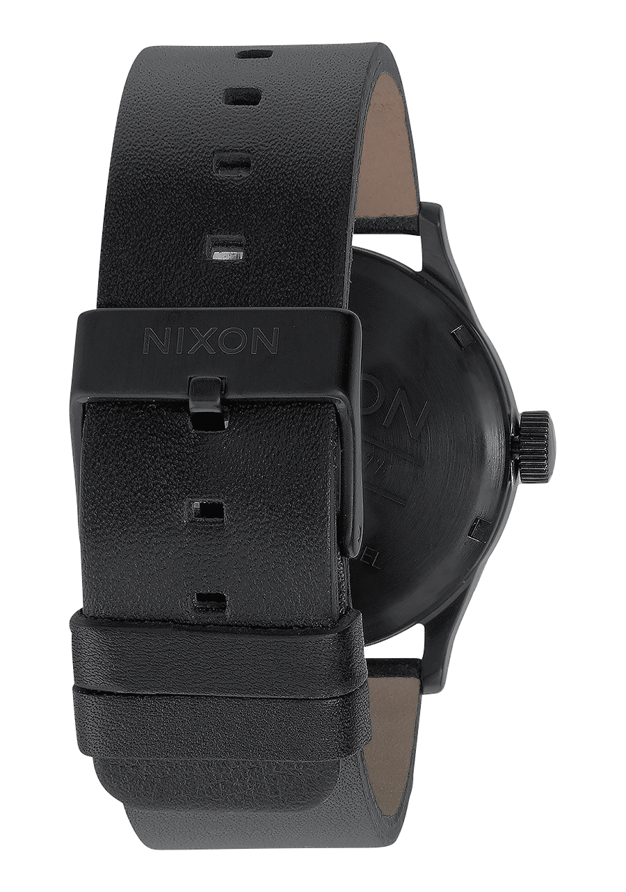 Black leather wristwatch with a minimalist design and ’NIXON’ branding on the strap.