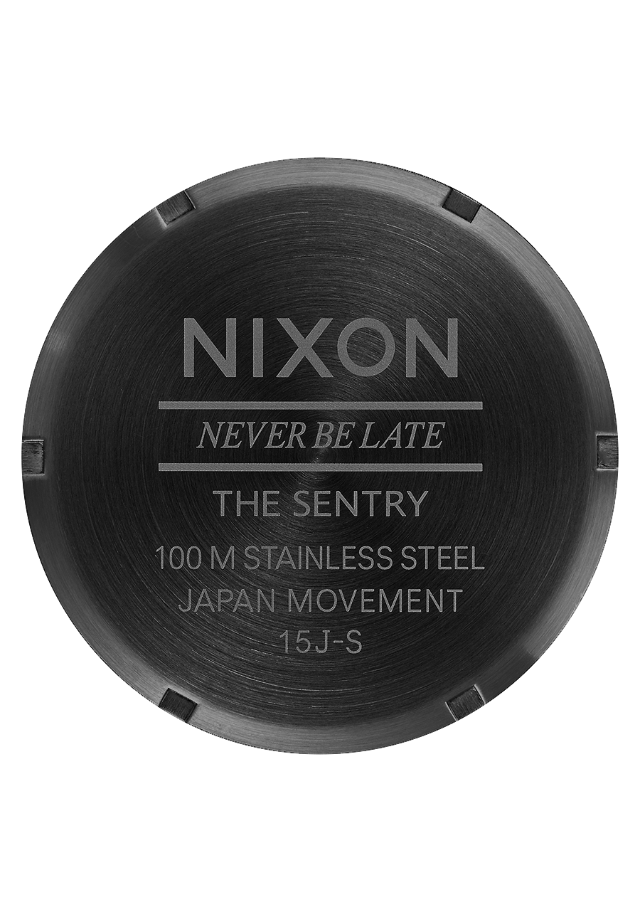 Back of a Nixon watch case displaying product details and the slogan ’NEVER BE LATE’.