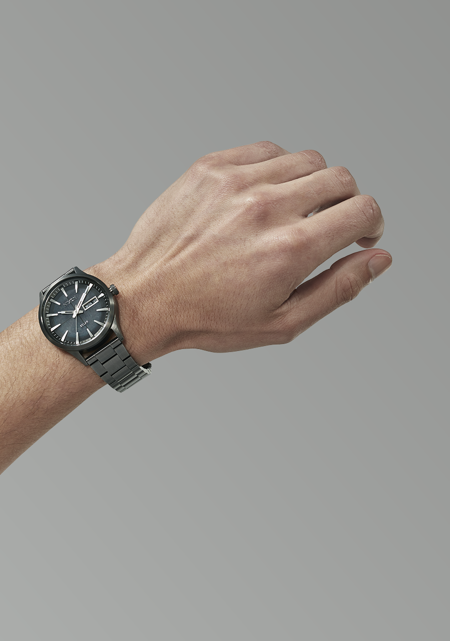 Wristwatch with a black dial and metal bracelet worn on a person’s wrist.