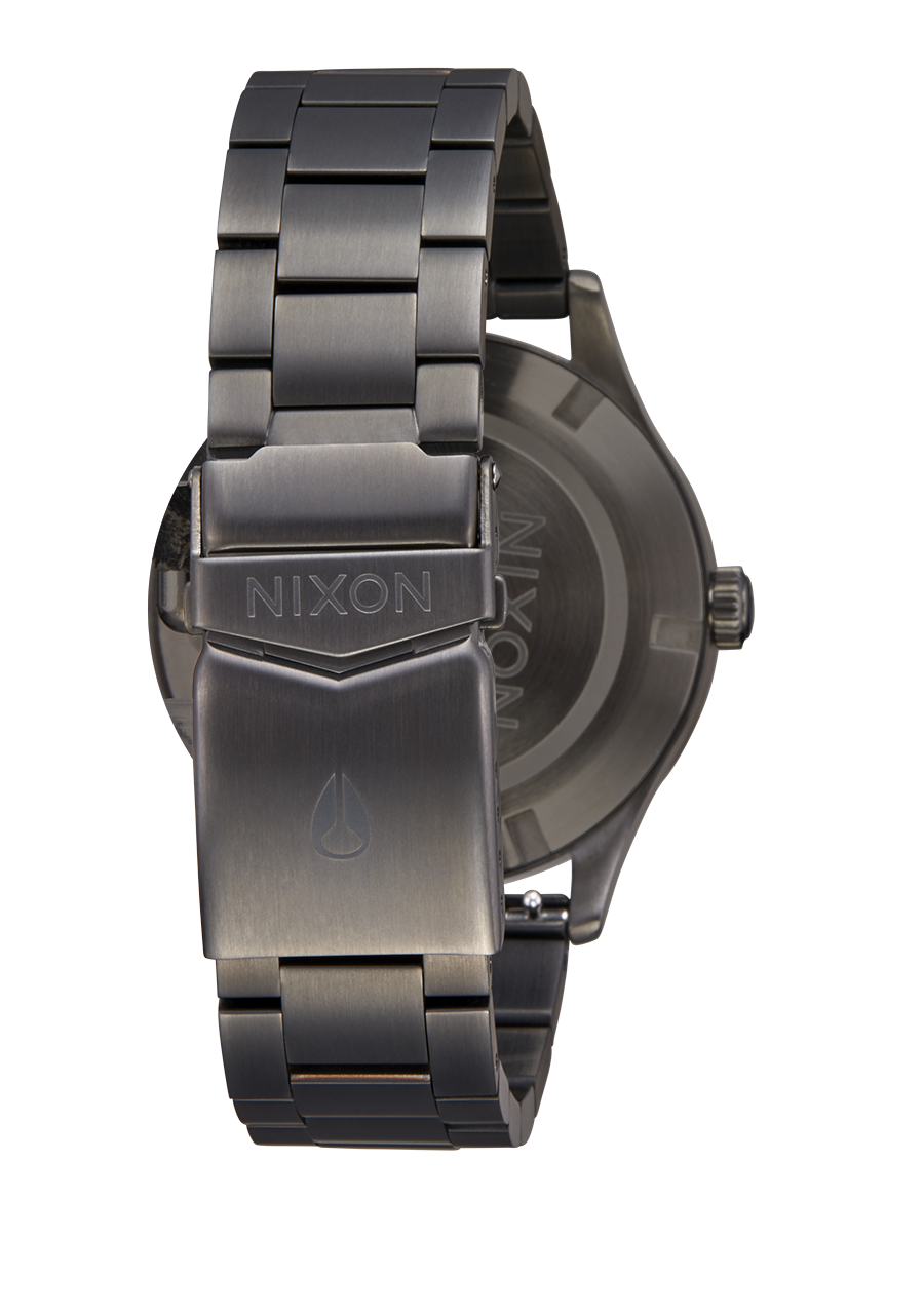 Gunmetal gray wristwatch with a metal bracelet and Nixon branding on the clasp.