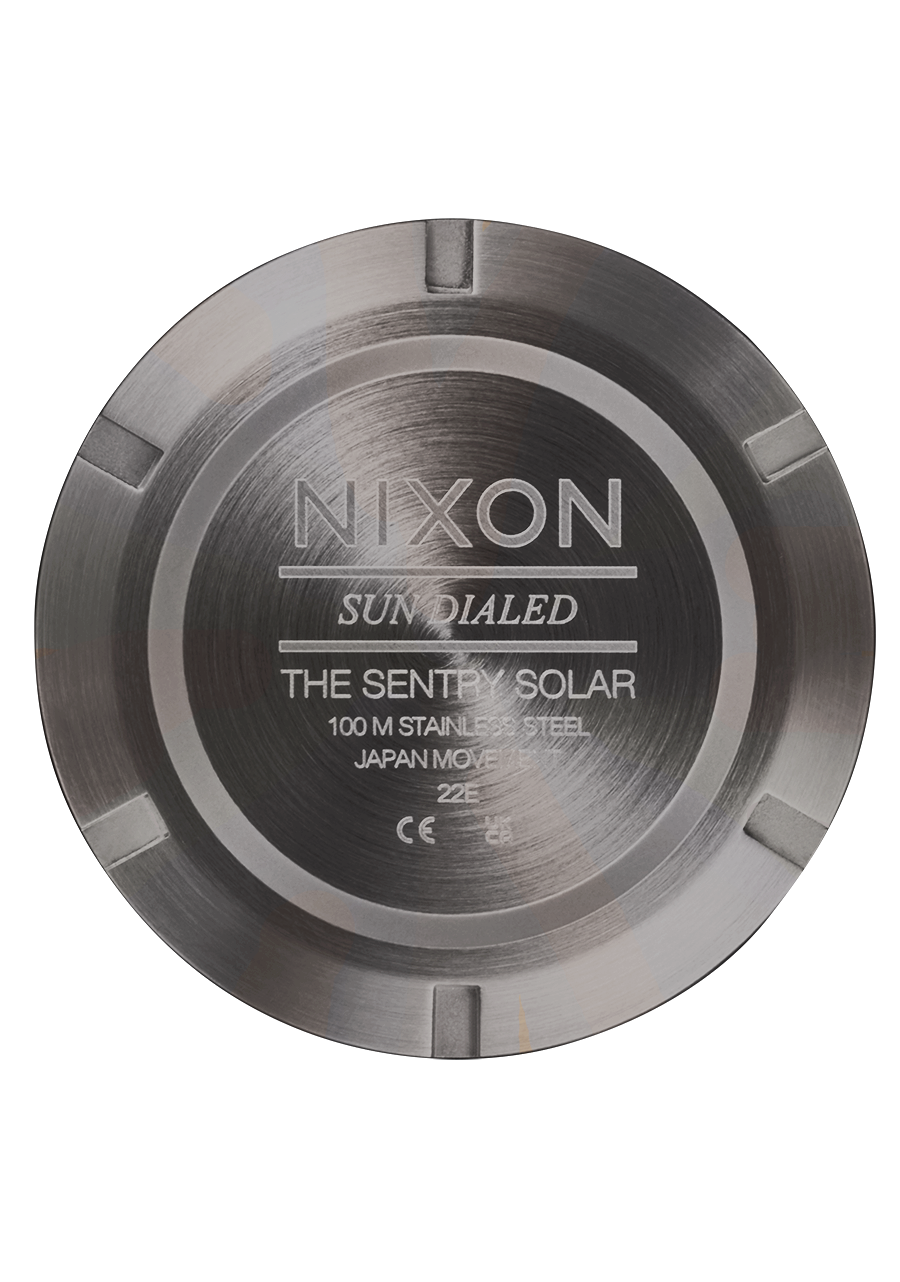 Circular metal back cover of a Nixon Sentry Solar watch displaying product information.