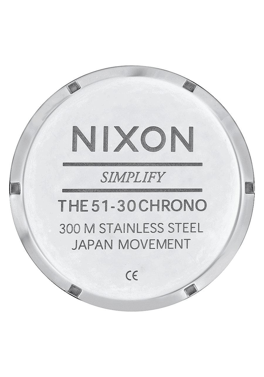 Circular metal watch case back engraved with Nixon brand and watch specifications.