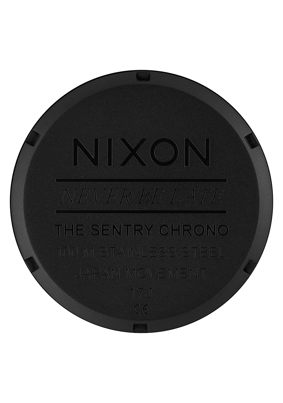 Circular black watch case back with engraved Nixon branding and product details.