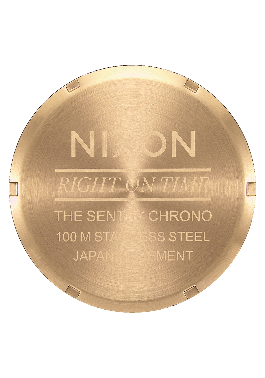 Circular gold-colored watch caseback with engraved text.
