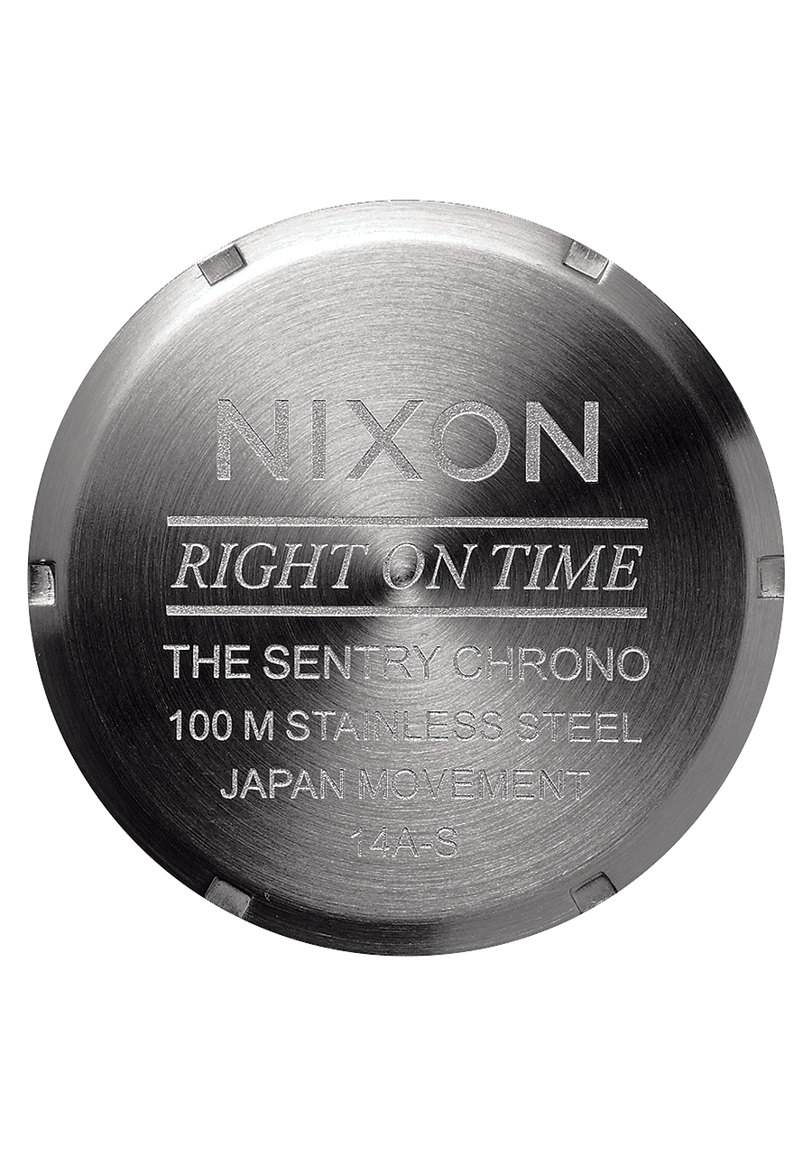 Circular metal watch case back engraved with ’Nixon’ and product details.