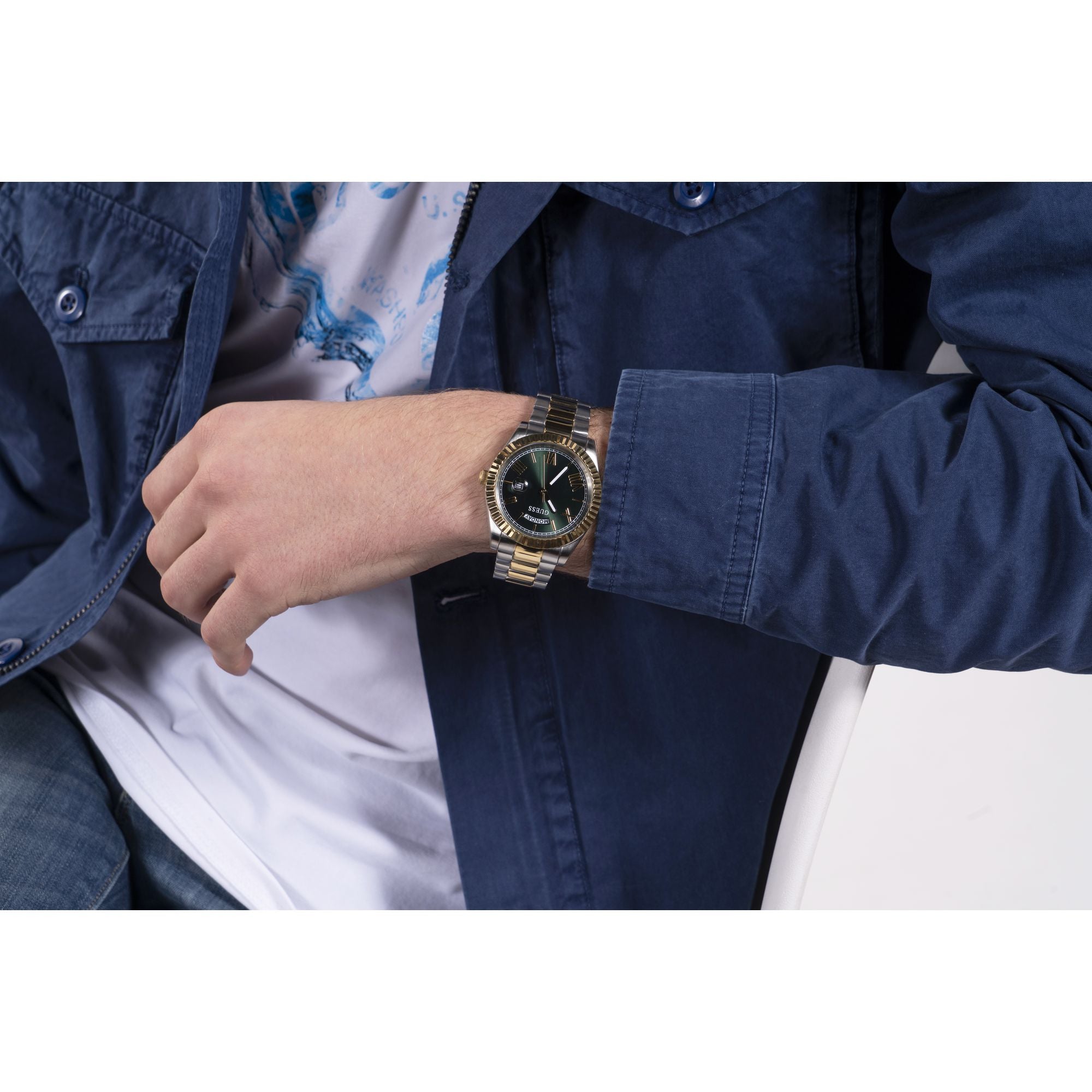 Gold Green Connoisseur Day-Date Watch GW0265G8 with gold-tone stainless steel case and green dial, worn with a stylish outfit.