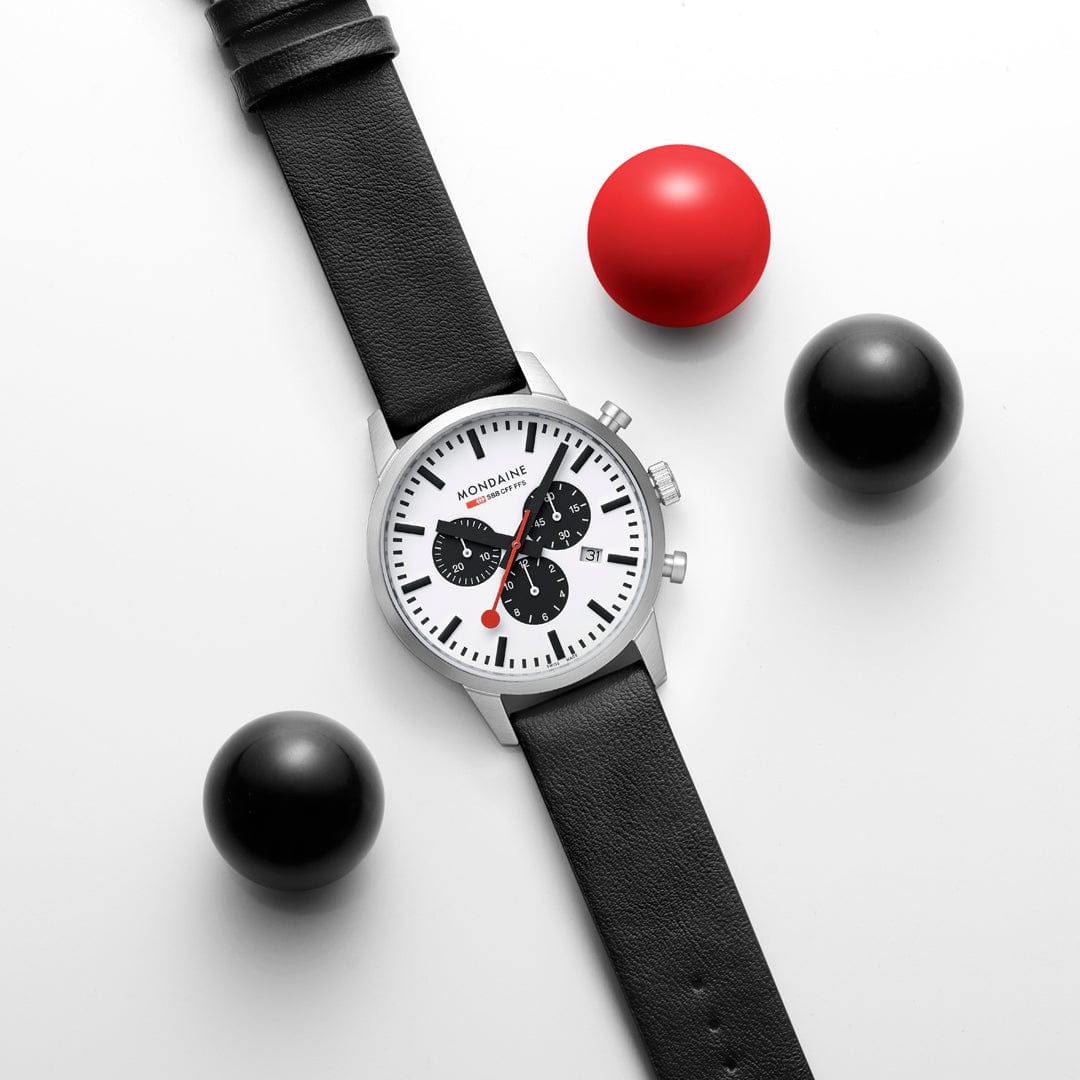 Wristwatch with a white face, black leather strap, and chronograph subdials.