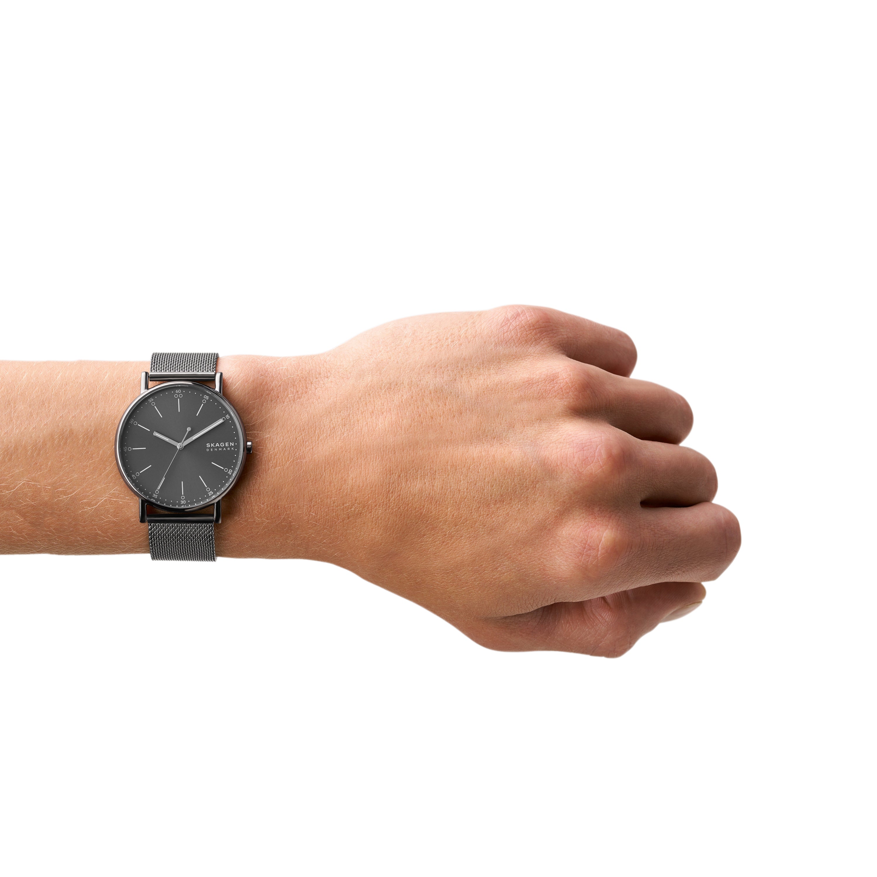 Wristwatch with a dark face and gray strap worn on a person’s wrist.