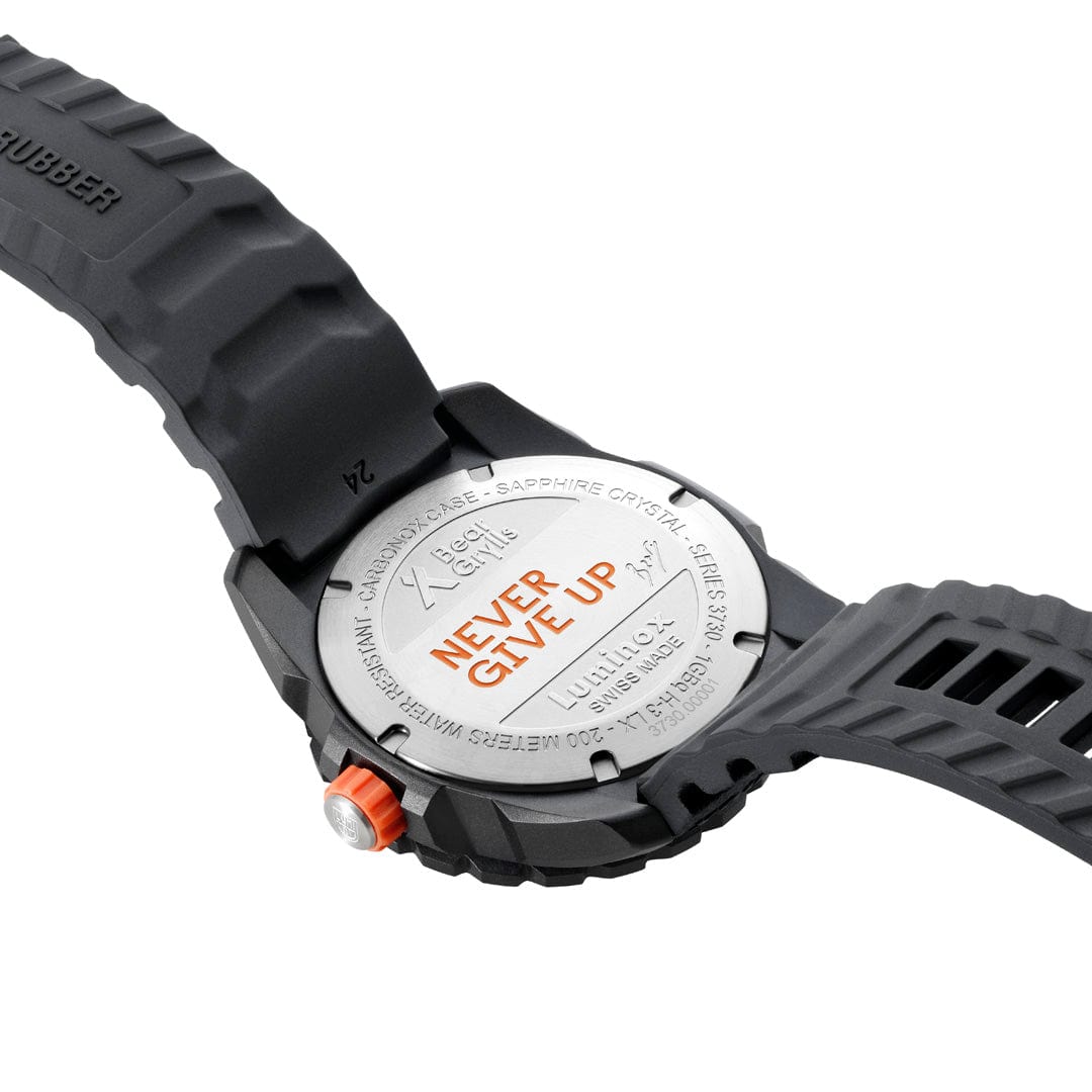 Wristwatch with a black rubber strap and a silver case back displaying text.