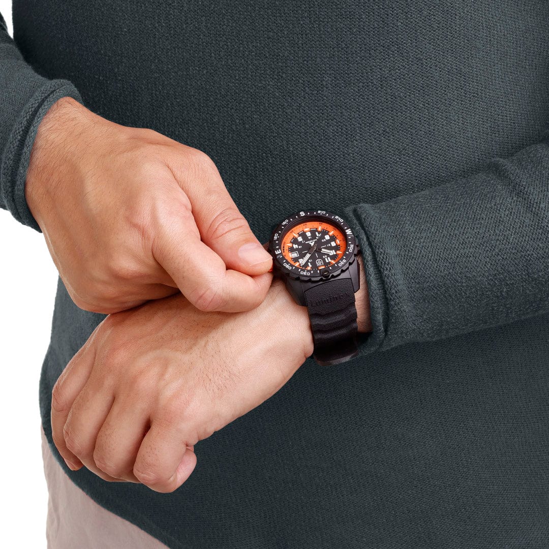 Wristwatch with a black band and orange accents on the face.