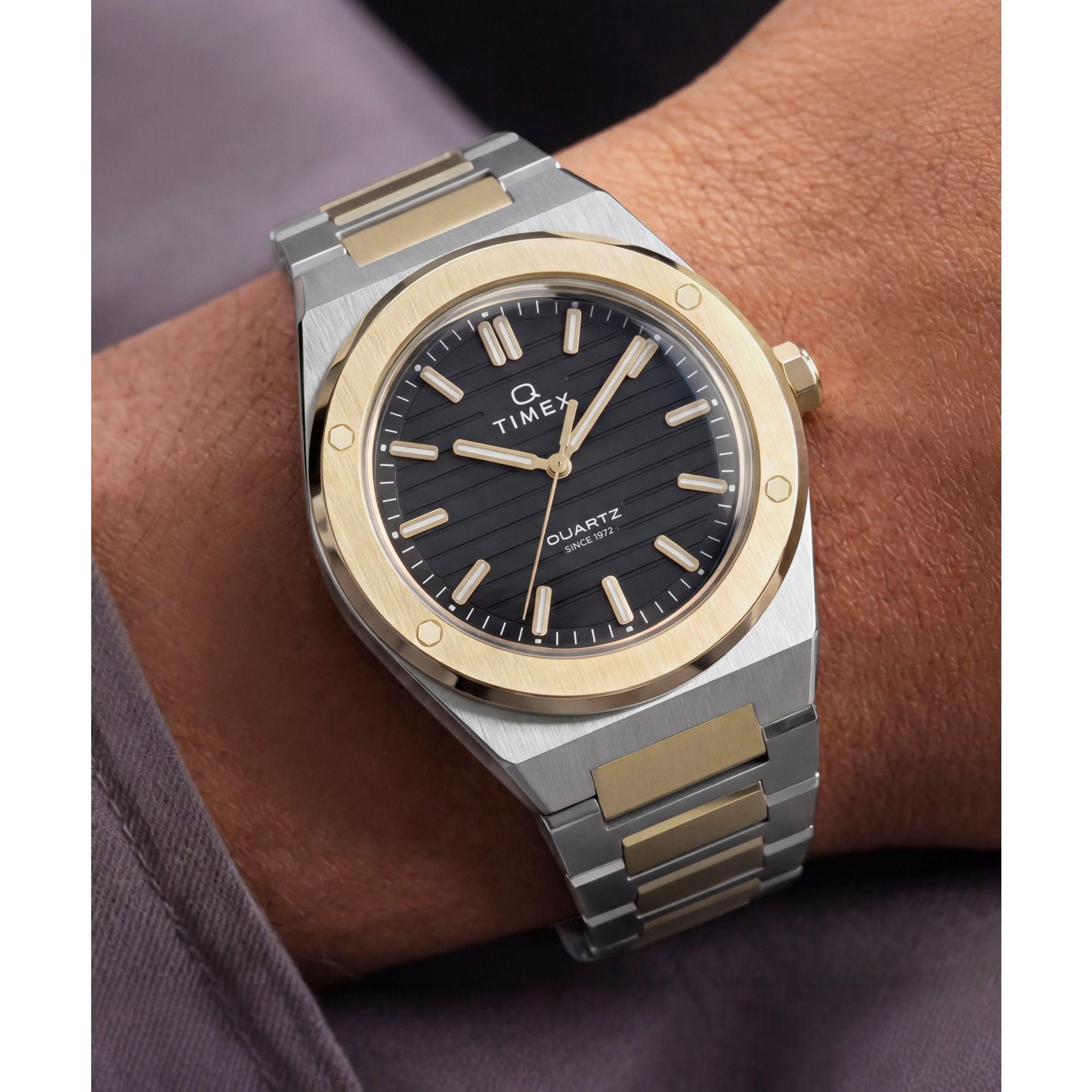 Timex Q Timex TW2Y81500 black ribbed dial with gold markers on a two-tone bracelet, worn on the wrist