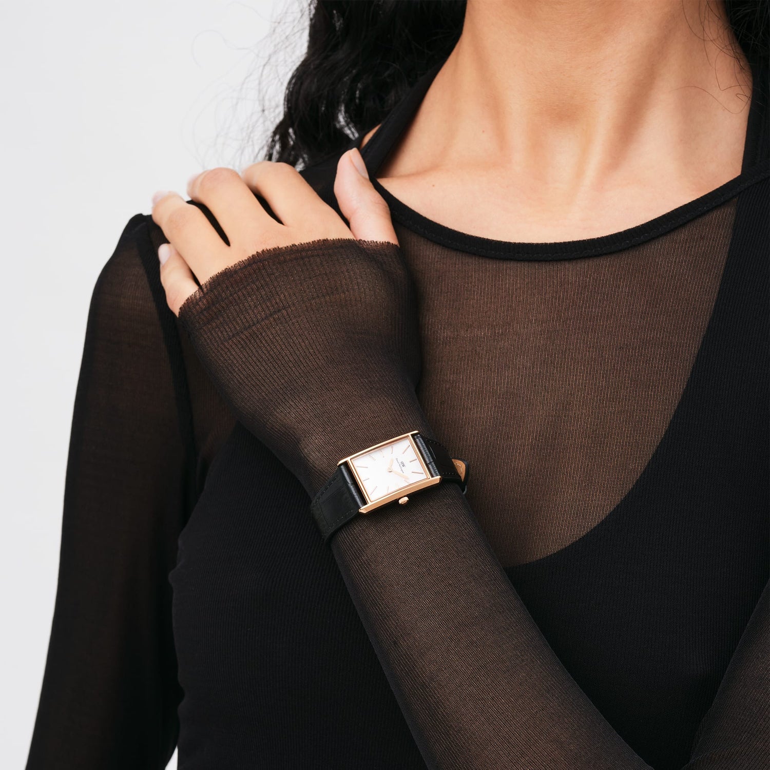 Wristwatch with a rectangular face and black leather strap.