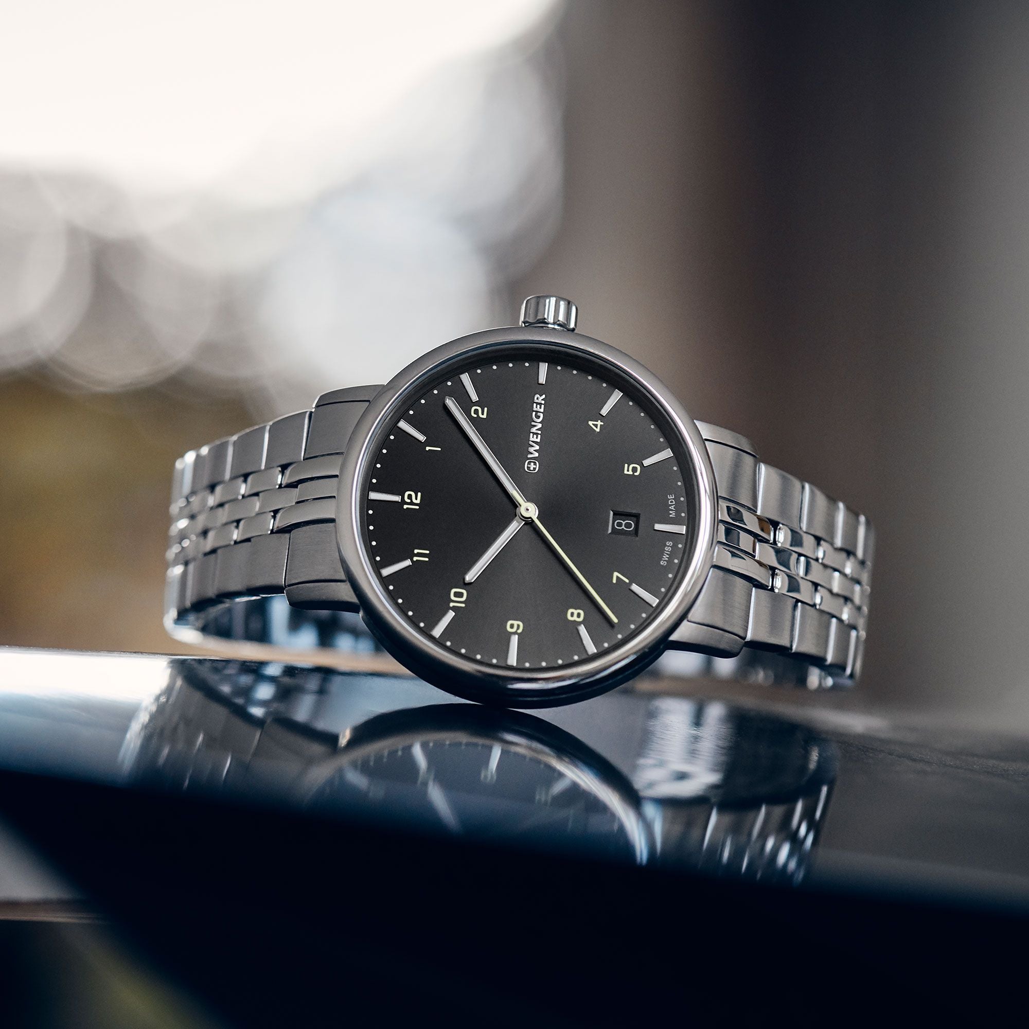 Sleek silver wristwatch with a black dial and metal bracelet.
