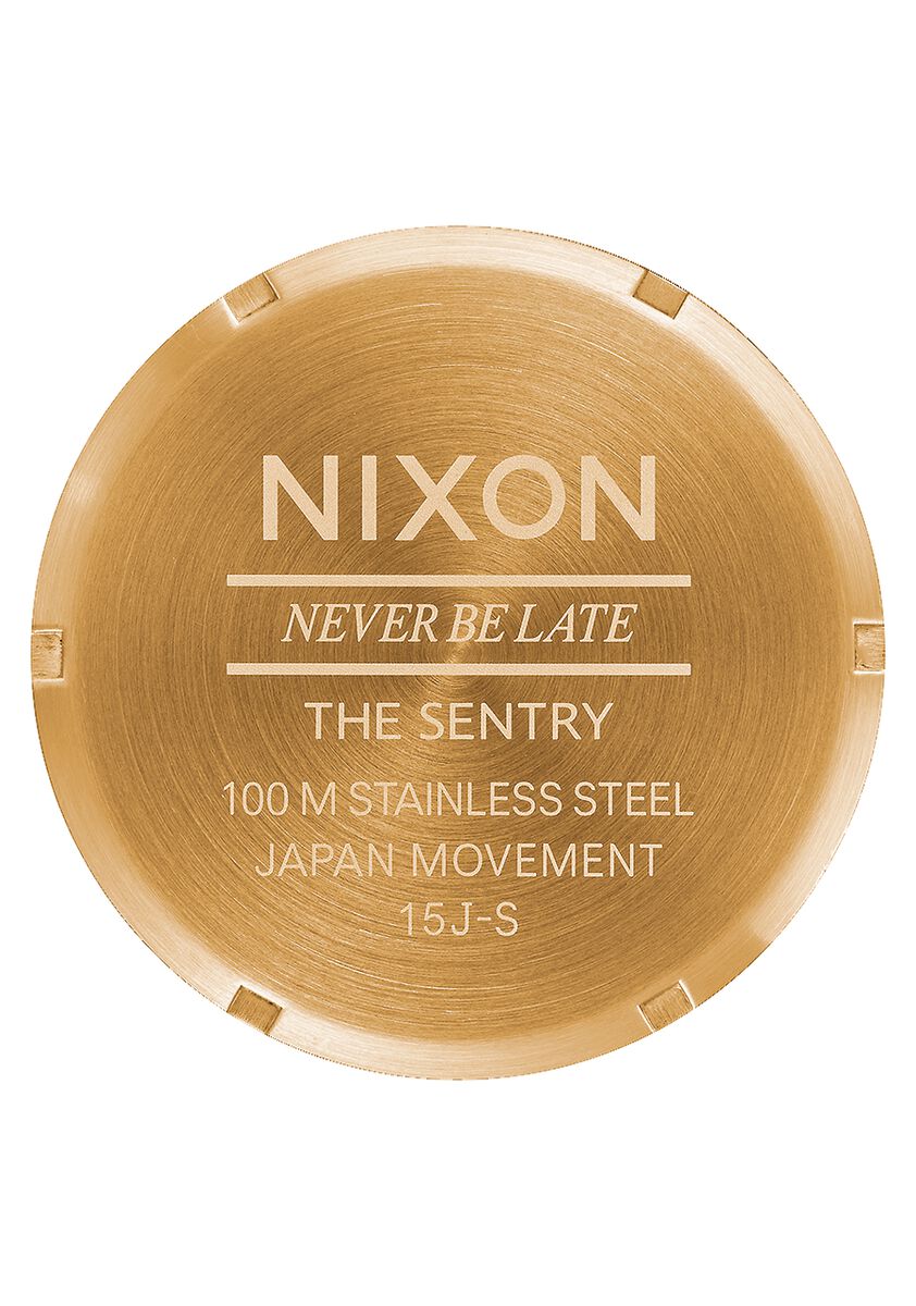 Circular gold-colored watch caseback with engraved text.