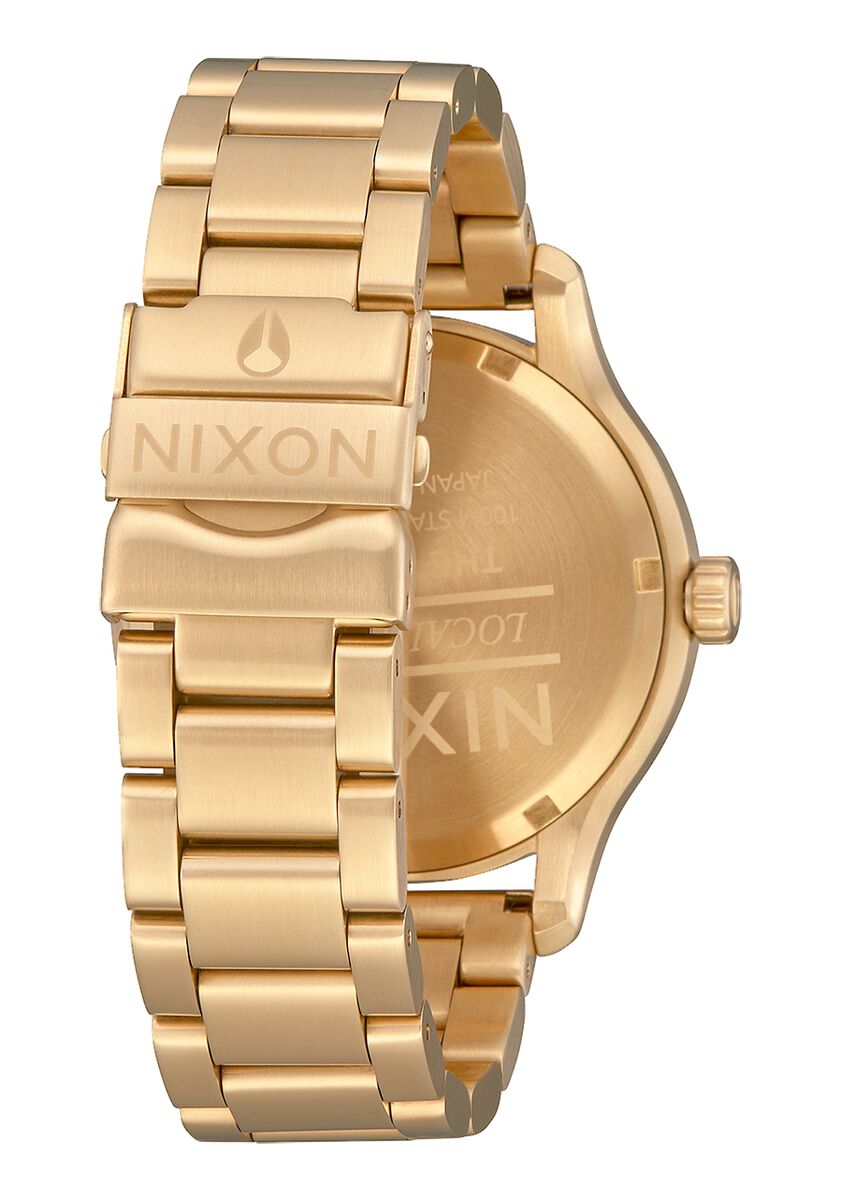 Gold-toned wristwatch with a metal bracelet band and Nixon branding.