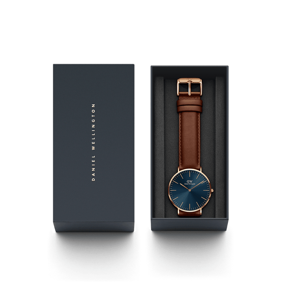 Wristwatch with a blue face and brown leather strap in a presentation box.