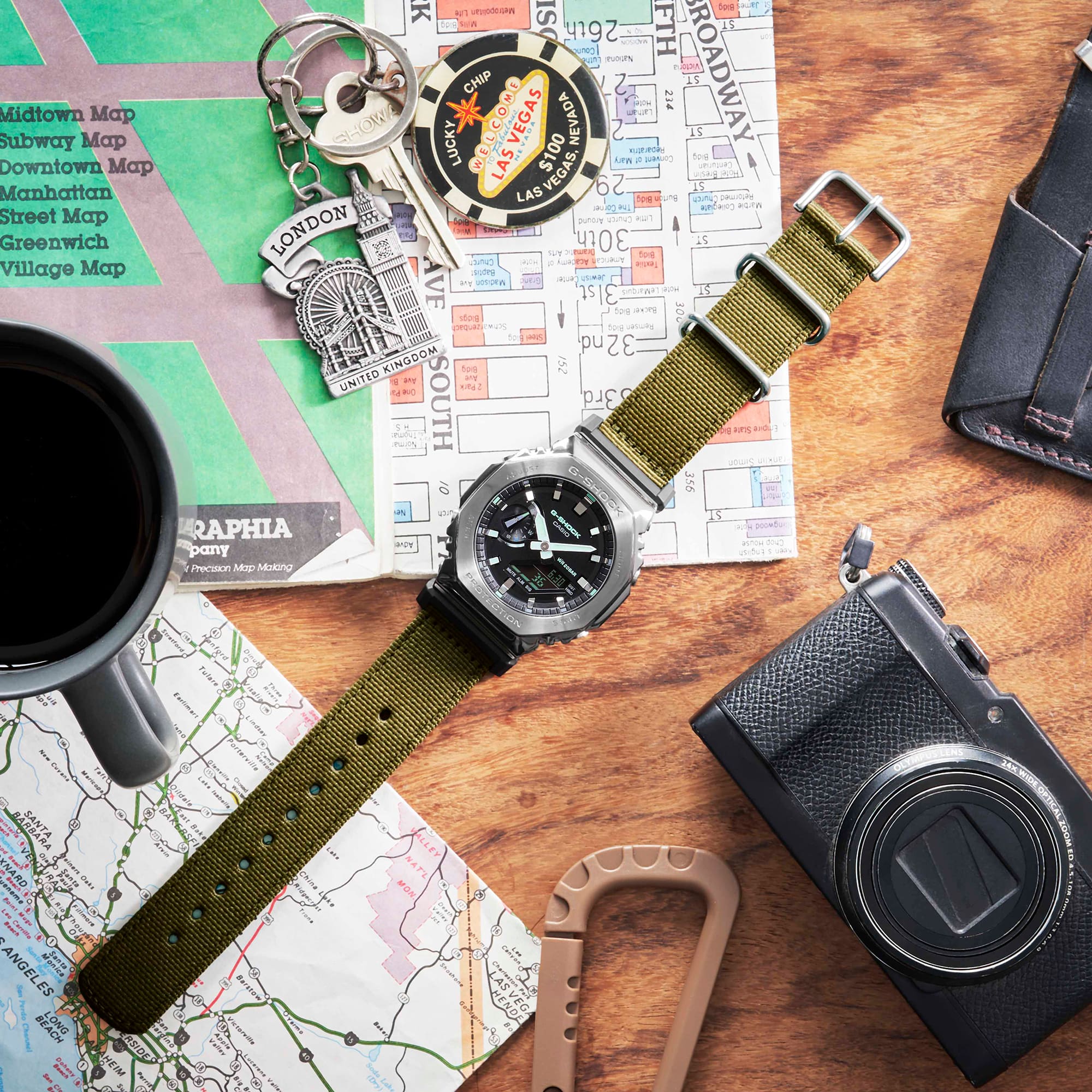 Wristwatch with a green canvas strap and black dial.