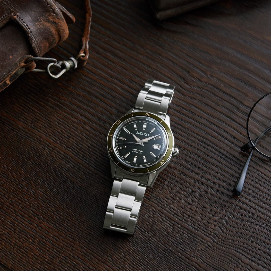 Stainless steel wristwatch with a black dial and metal bracelet.