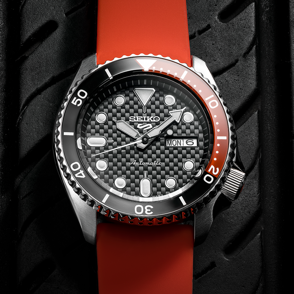 Seiko 5 Sports dive watch with a black and red bezel on a red strap.