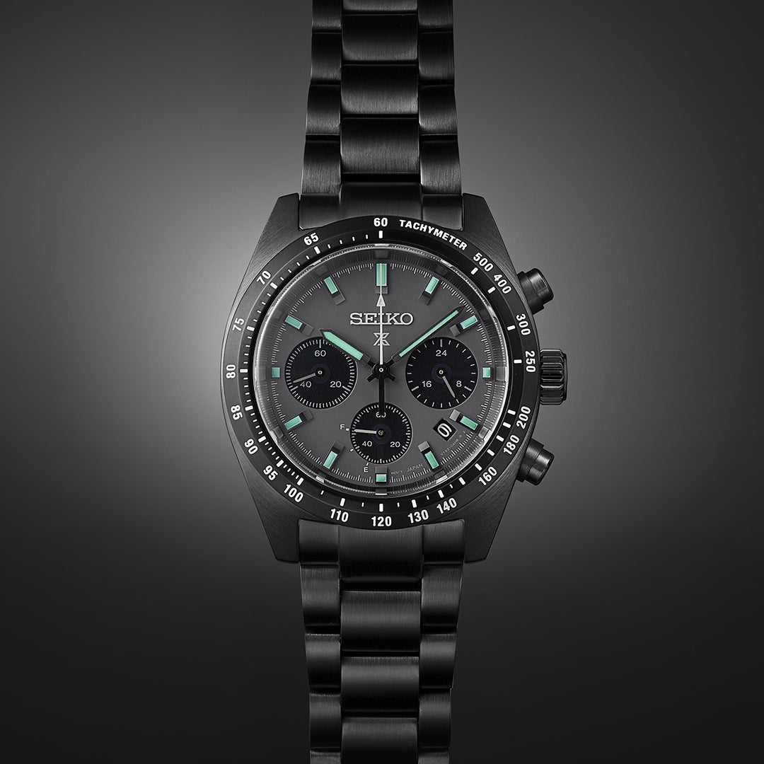 Black Seiko chronograph wristwatch with a metal bracelet and tachymeter bezel.