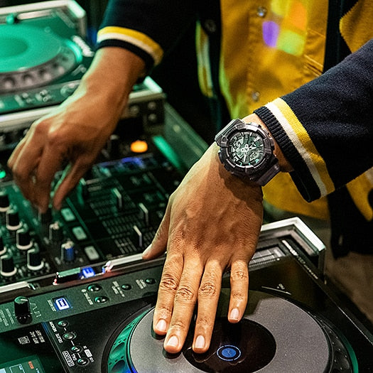 DJ turntable and mixer setup with hands operating the equipment.