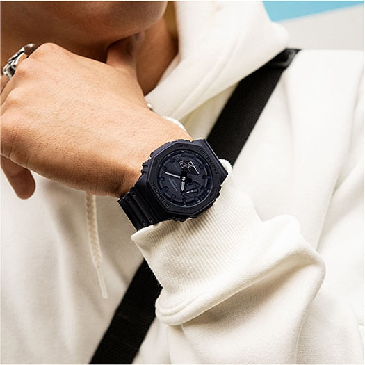 Black sports watch with a round face and textured bezel worn on a wrist.