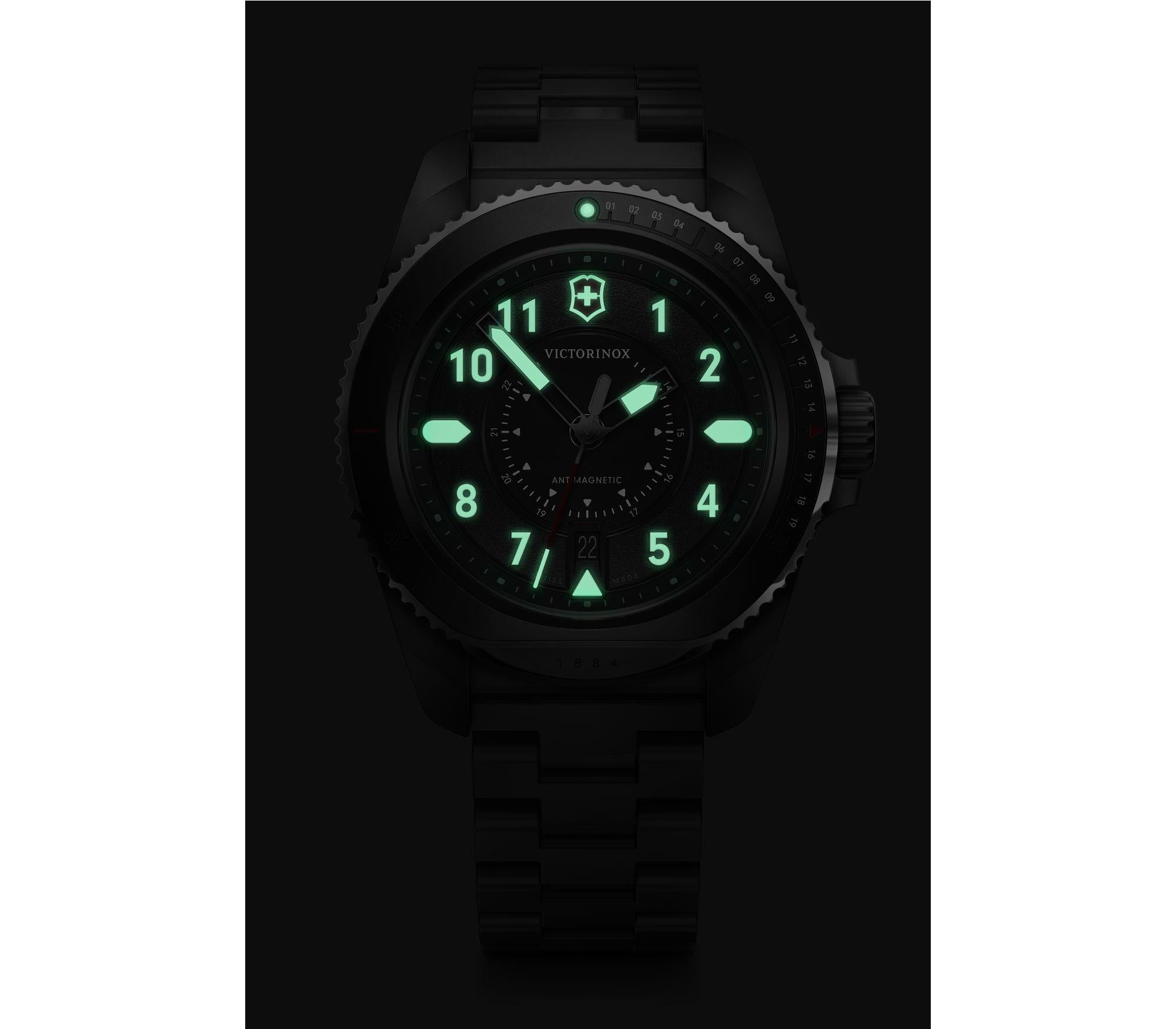 Luminous watch face with glowing green numbers and markings in darkness.