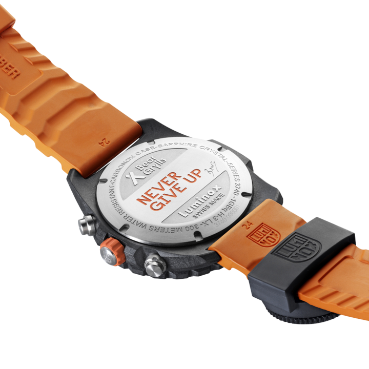 Wristwatch with an orange rubber strap and a silver-colored case back displaying text.
