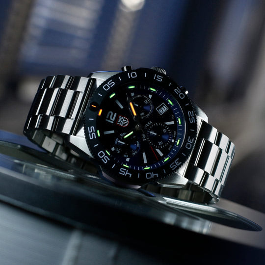 Sleek stainless steel wristwatch with a black face and colorful markings.