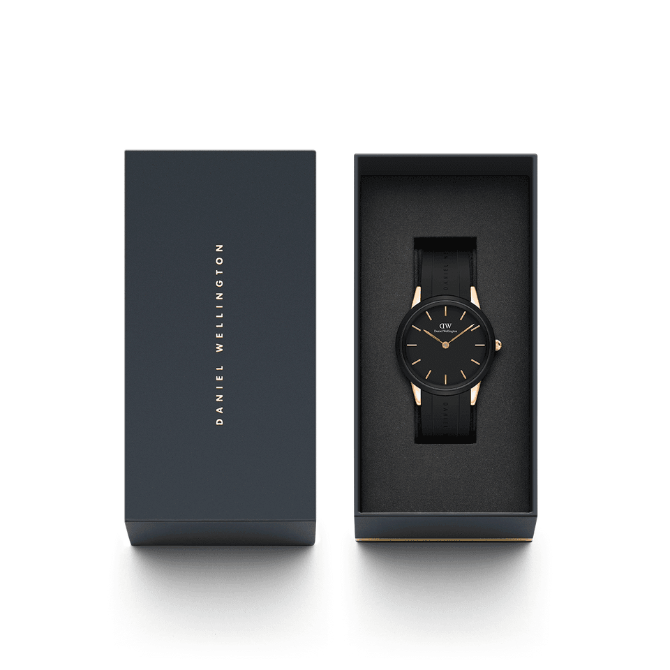Sleek black wristwatch with gold accents in an open presentation box.