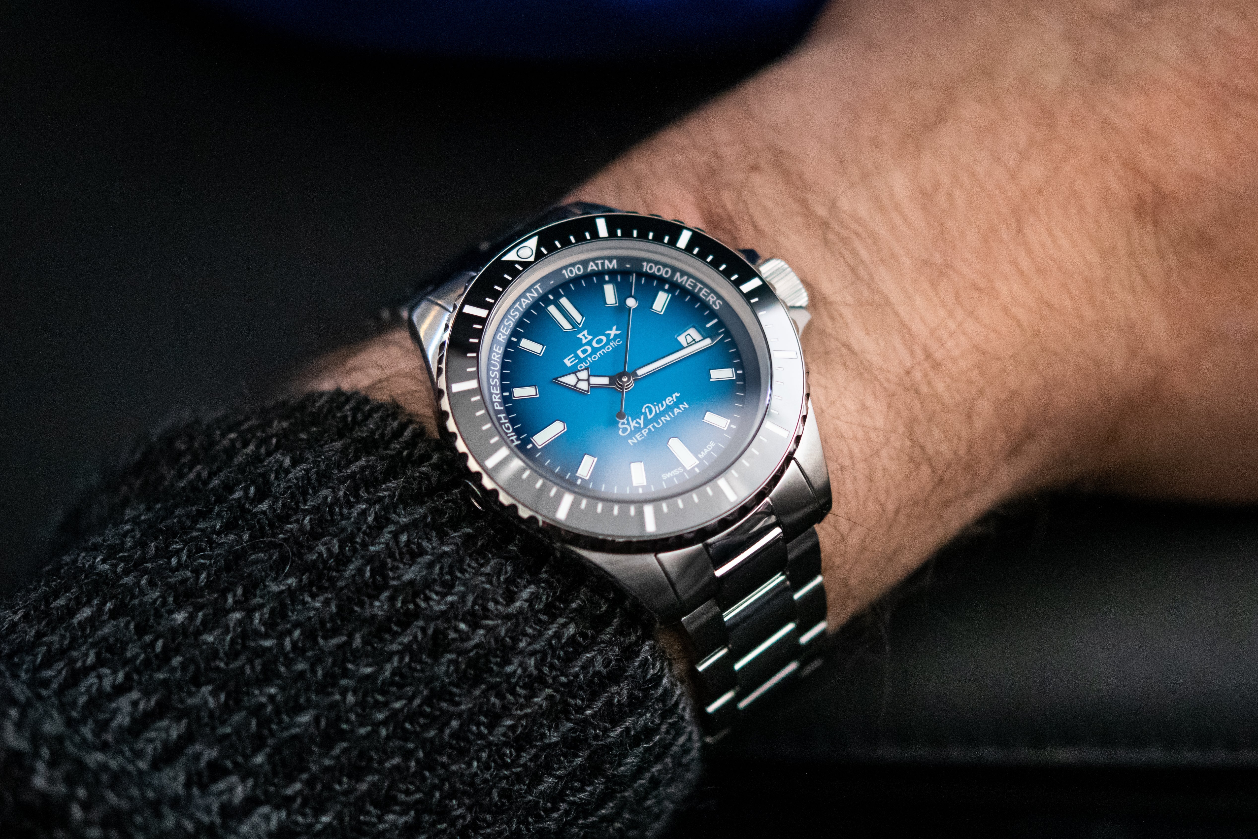 men's wrist with a blue dial watch on