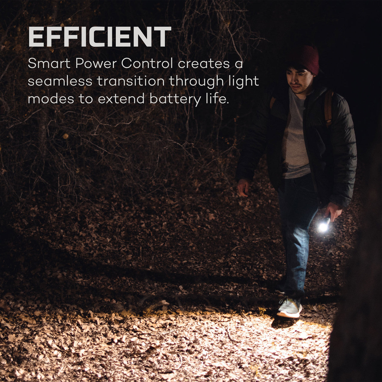 Person using a bright flashlight or headlamp in a dark outdoor setting.