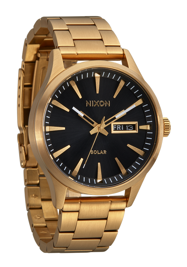 Gold-toned wristwatch with a black dial face displaying the Nixon brand name.