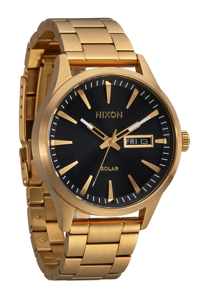 Gold-toned wristwatch with a black dial face displaying the Nixon brand name.