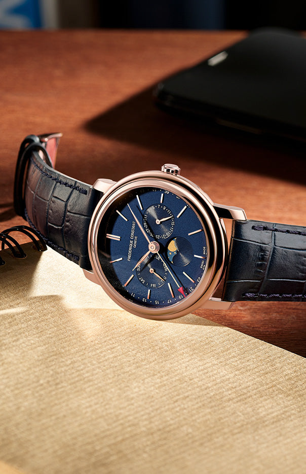 Elegant wristwatch with a blue dial, gold-tone case, and black leather strap.