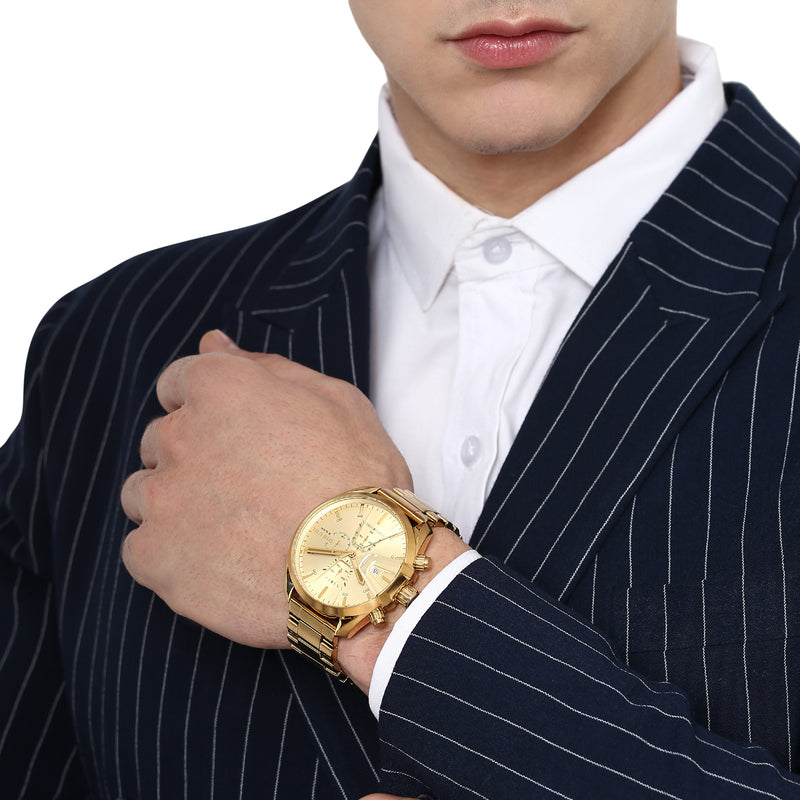 Gold wristwatch with a chronograph dial worn on a person’s wrist.