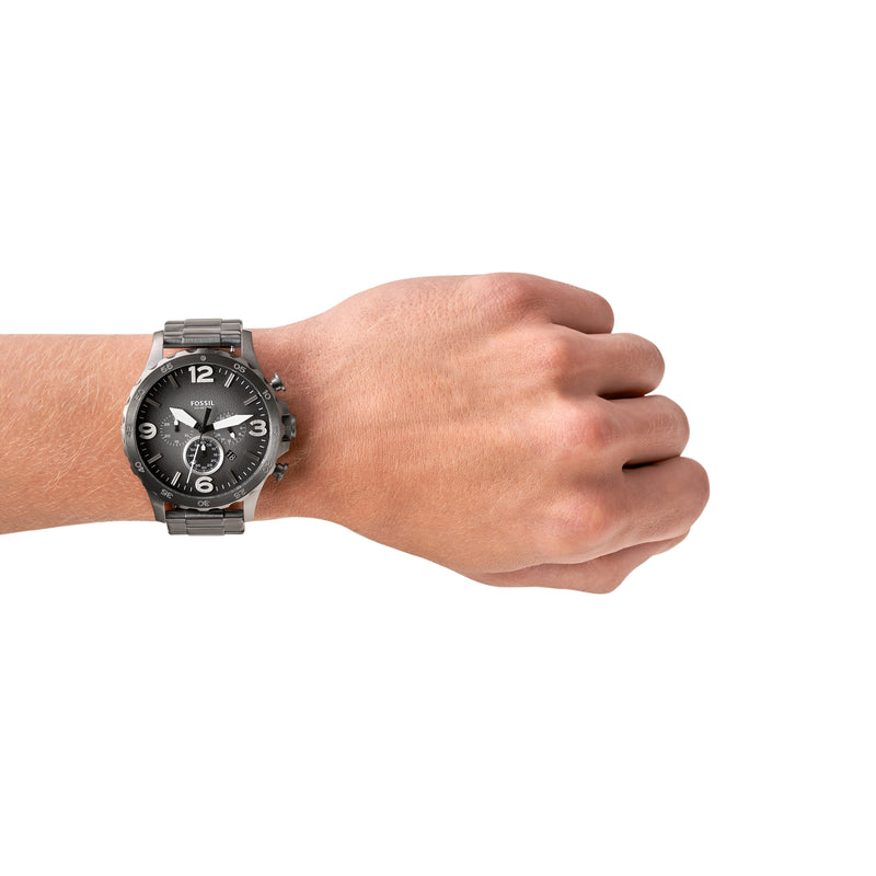 Wristwatch with a dark metallic band worn on a person’s wrist.