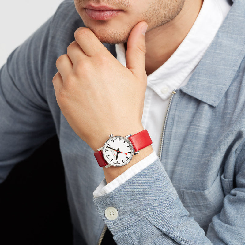 Wristwatch with a white face and bright red band.