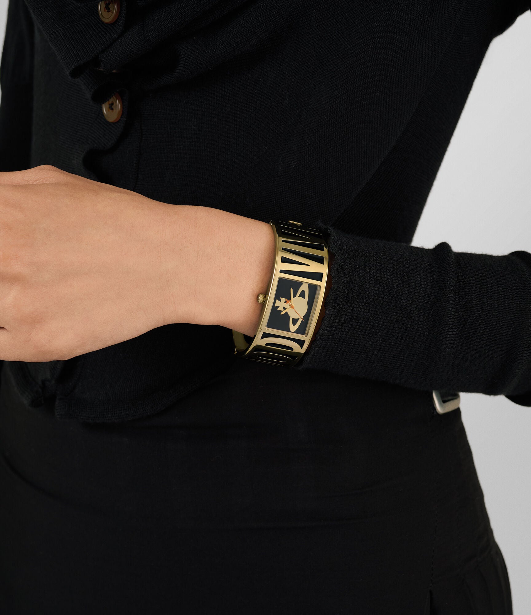 Vivienne Westwood Belvoir women's watch with a black dial and gold bangle. Close-up detail view.