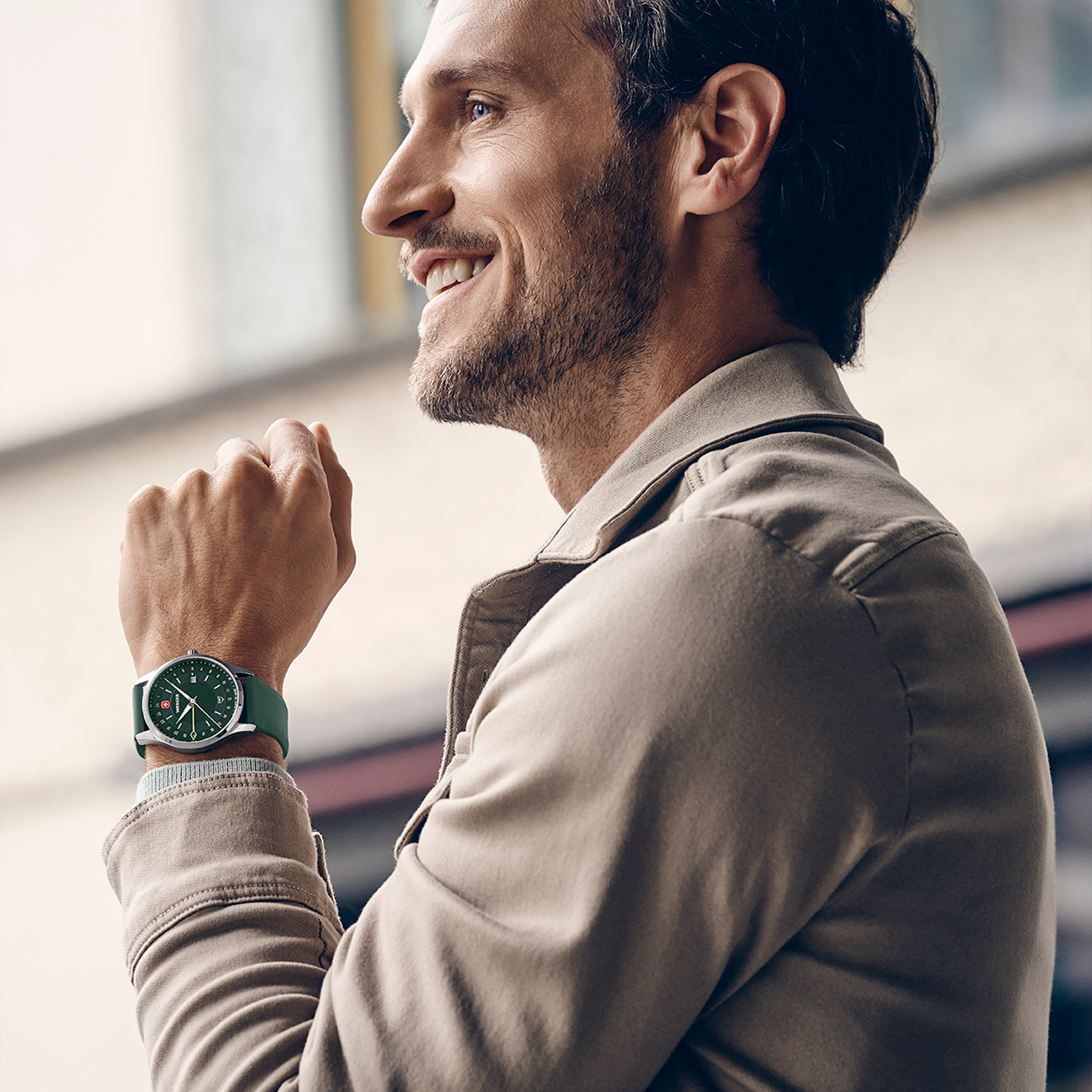 Lifestyle image of the Wenger City GMT 42 01.1442.101 green dial watch on its green silicone strap