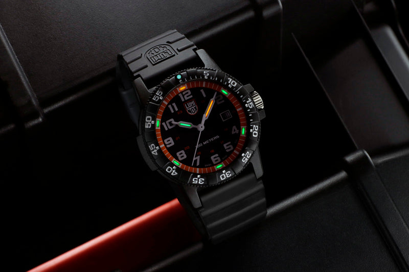 Black sports watch with a colorful analog dial and luminous hands.