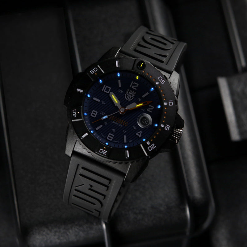 Sleek black wristwatch with illuminated blue and yellow markings on its face.