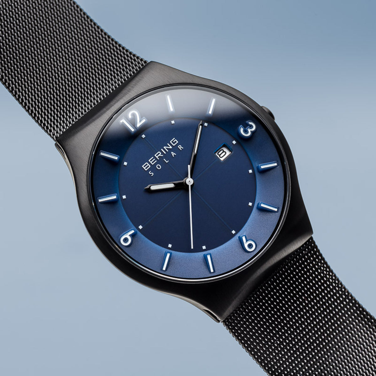 Sleek wristwatch with a blue dial and black mesh strap.