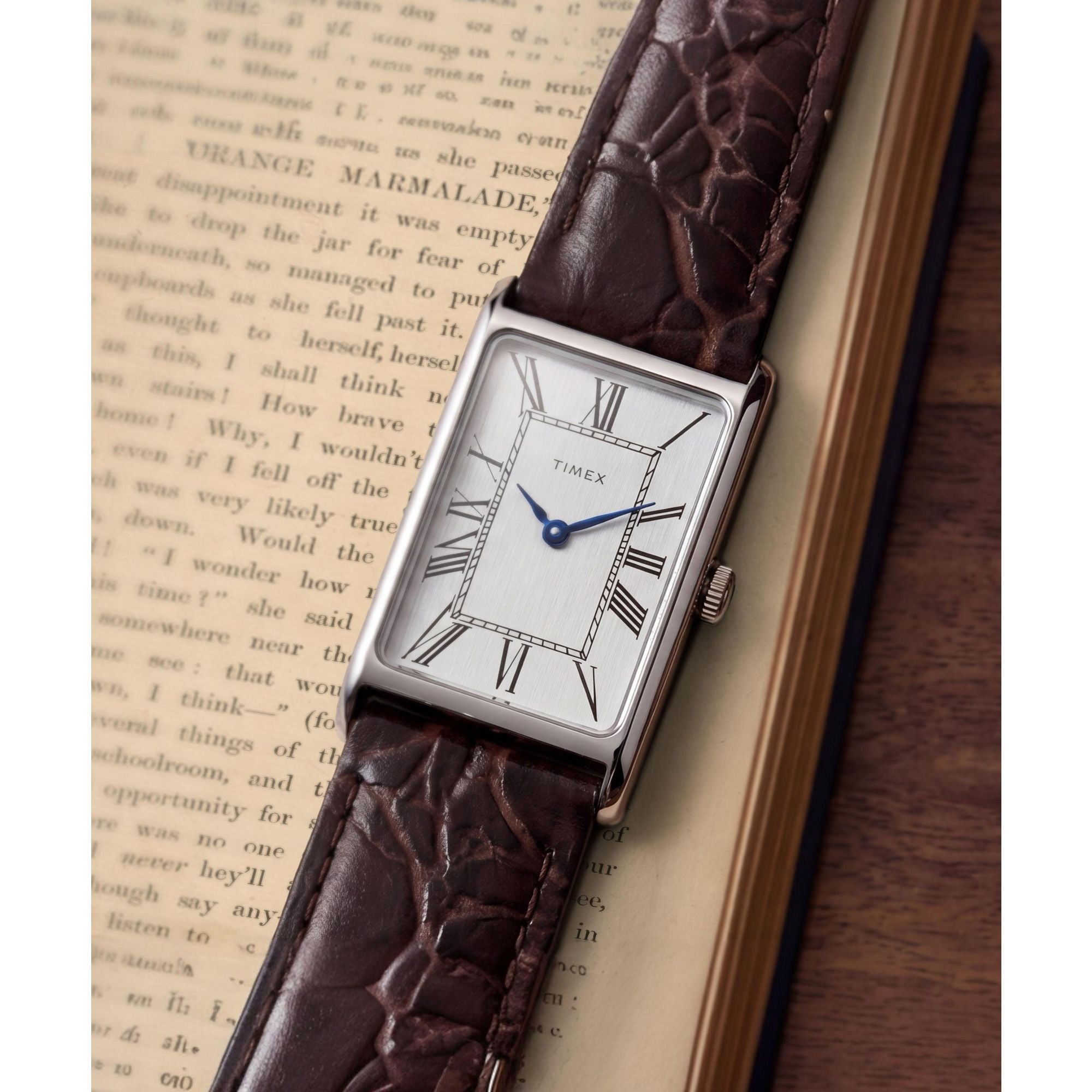 Timex 1976 Lexington TW2Y88200 silver dial with Roman numerals on a brown leather strap, dial close-up