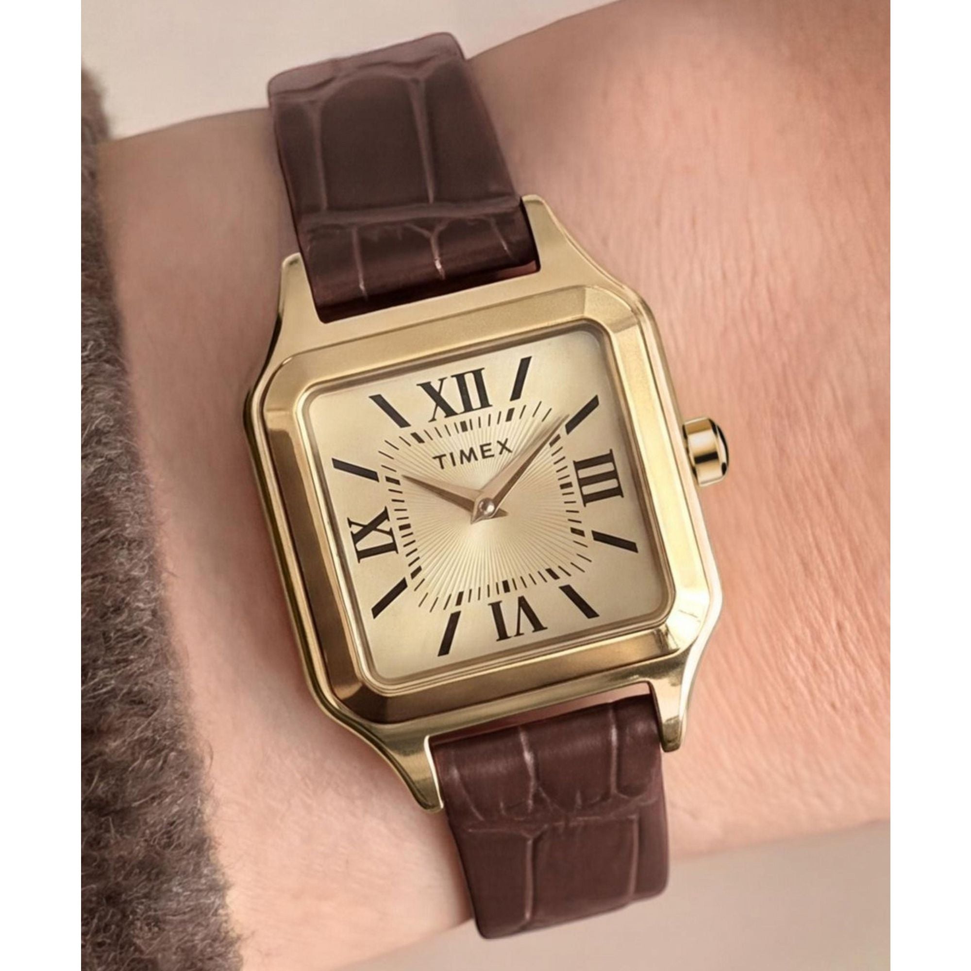 Timex Addison TW2Y90700 champagne dial with Roman numerals on a brown leather strap, worn on the wrist