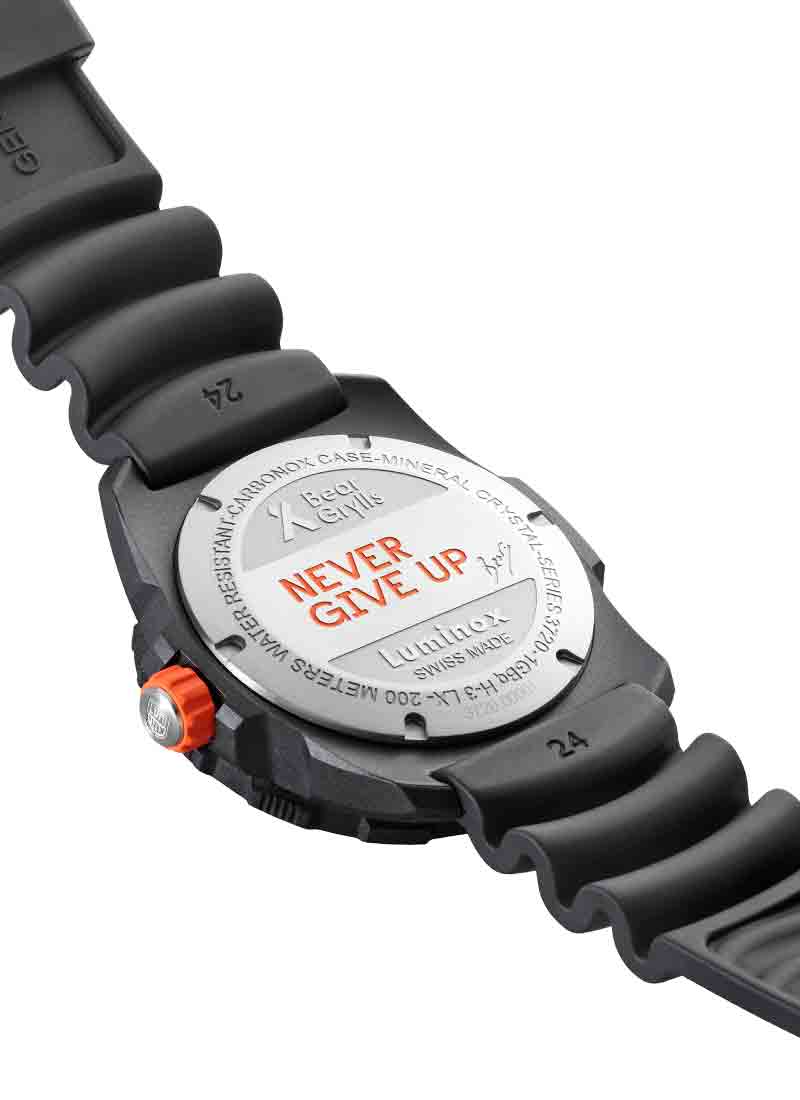 Wristwatch with a black rubber strap and a silver caseback engraved with ’NEVER GIVE UP’.
