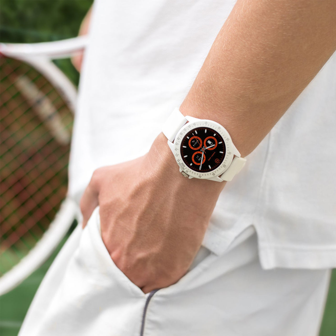 Smartwatch with a round face and white band worn on a wrist.